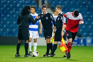 Referee Reuben Simon shakes hands with his assistants before kick-off