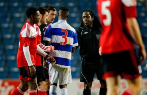 Referee Reuben Simon shakes hands with his assistants and players after the final whistle